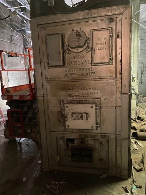 The original boiler's cast-iron door and nameplate before removal at the York City Auditorium